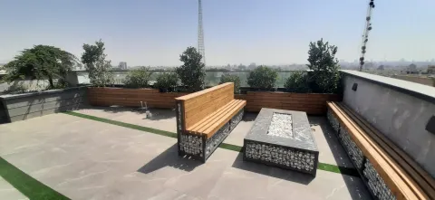روف‌گاردن با نیمکت چوبی، گابیون سنگی و منظره شهر